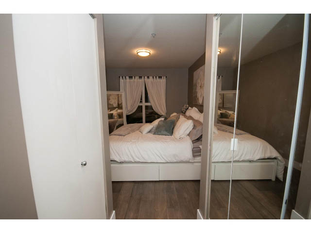 Furnished bedroom with hardwood floors and mirrored closet doors. - 106 - 1868 W. 5th Avenue, Vancouver West Side