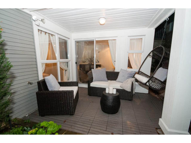 Furnished patio with wicker furniture and sliding glass doors. - 106 - 1868 W. 5th Avenue, Vancouver West Side