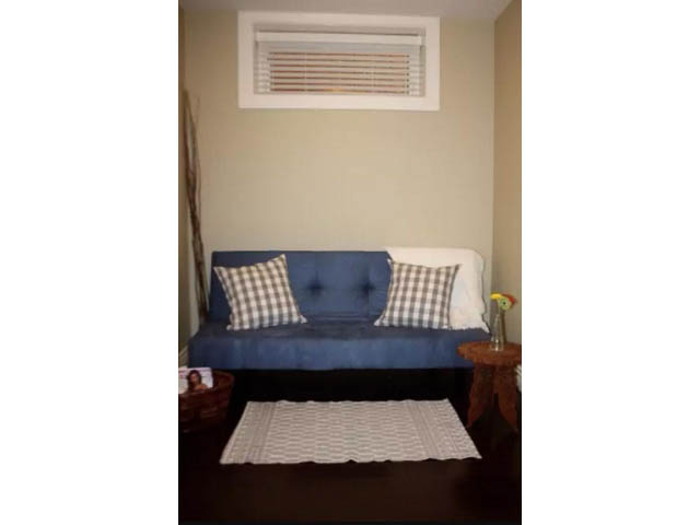 Furnished living room with blue couch, checkered pillows, and white rug. - 188 West 23rd Ave, Vancouver West Side