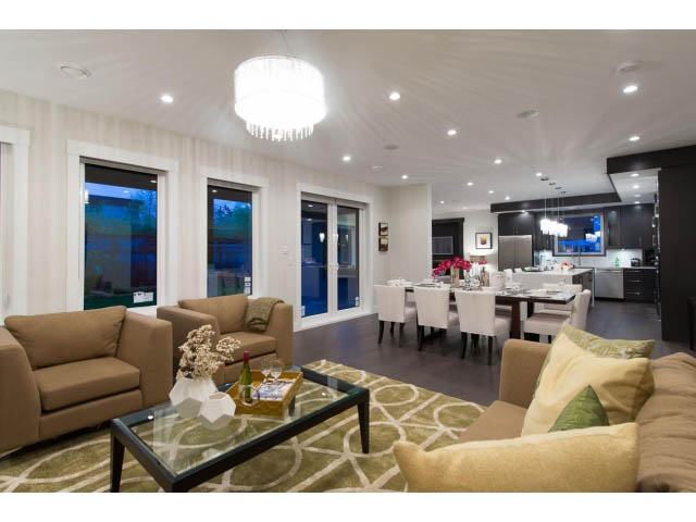 Spacious living room with modern decor, large windows, and a cozy sectional. - 3192 Beverley Cres, North Vancouver