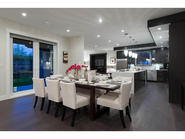 Elegant dining room with hardwood floors, modern chandelier, and city view. - 3192 Beverley Cres, North Vancouver