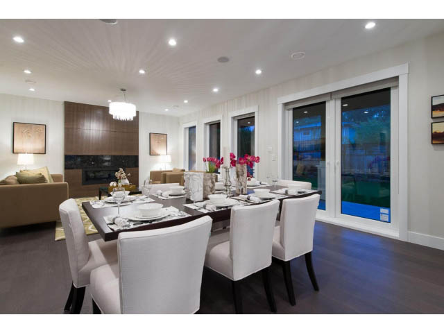 Elegant dining room with white chairs, hardwood floors, and a city view. - 3192 Beverley Cres, North Vancouver