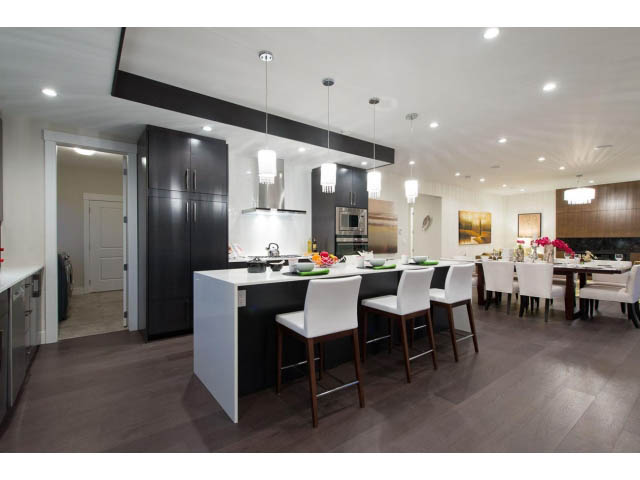 Spacious open-concept living area with modern kitchen, white countertops, hardwood floors, and a city view. - 3192 Beverley Cres, North Vancouver