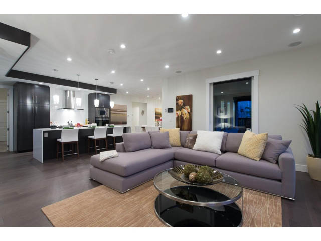Open-concept living room with modern furnishings, hardwood floors, and a city view. - 3192 Beverley Cres, North Vancouver