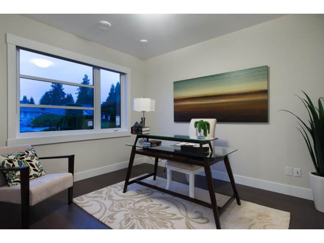 Living room with modern decor, large window view, and abstract wall art. - 3192 Beverley Cres, North Vancouver