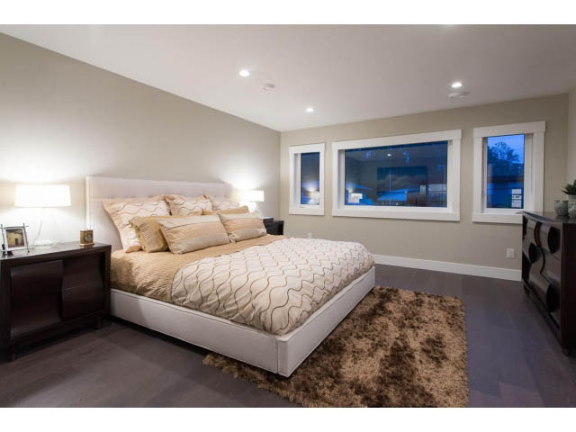 Spacious bedroom with modern furnishings, large windows, and plush rug. - 3192 Beverley Cres, North Vancouver