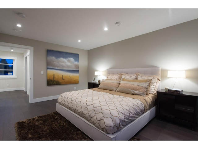 Spacious bedroom with modern decor, large bed, and artwork on the wall. - 3192 Beverley Cres, North Vancouver