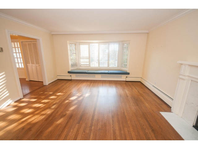 Bright living room with hardwood floors and bay window. - 1145 Sutton Place, West Vancouver