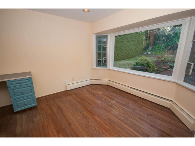 Bright living room with hardwood floors and bay window view. - 1145 Sutton Place, West Vancouver