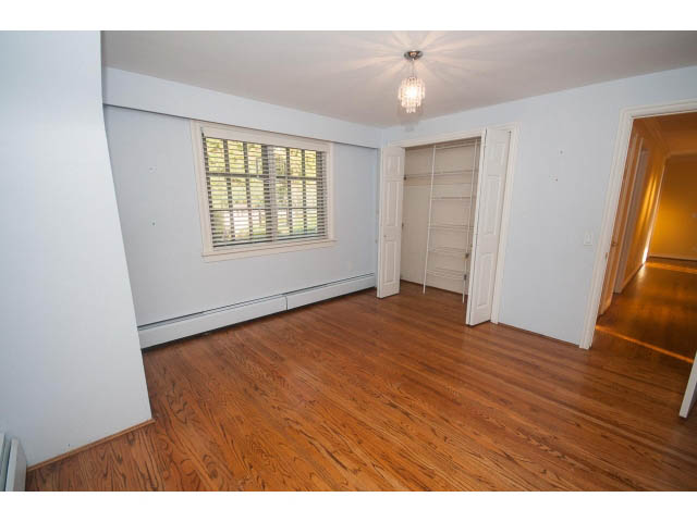 Spacious bedroom with hardwood floors and a closet. - 1145 Sutton Place, West Vancouver