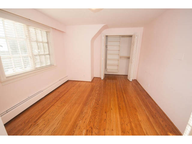 Bright bedroom with hardwood floors and a large closet. - 1145 Sutton Place, West Vancouver