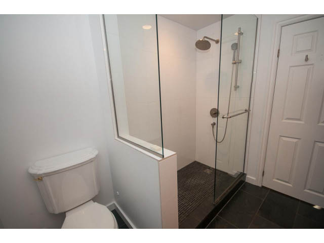 Small bathroom with white fixtures and glass shower enclosure. - 1145 Sutton Place, West Vancouver