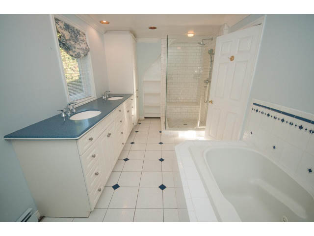 Spacious bathroom with blue countertops and white tile floor. - 1145 Sutton Place, West Vancouver