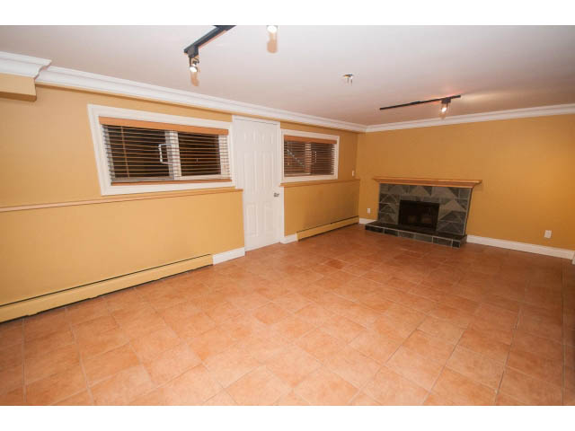 Bright living room with tiled floor and fireplace, clean and ready for move-in. - 1145 Sutton Place, West Vancouver