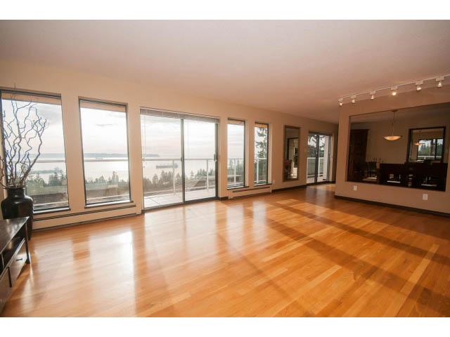 Bright living room with hardwood floors and a stunning city view. - 4251A Rockbank, West Vancouver