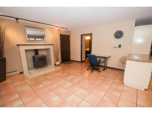 Bright living room with tiled floor, fireplace, and open layout. - 4251A Rockbank, West Vancouver