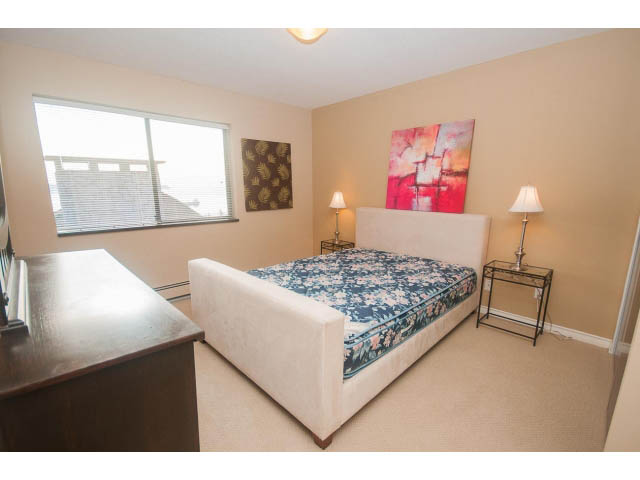 Spacious bedroom with a large bed, artwork, and a desk area. - 4251A Rockbank, West Vancouver