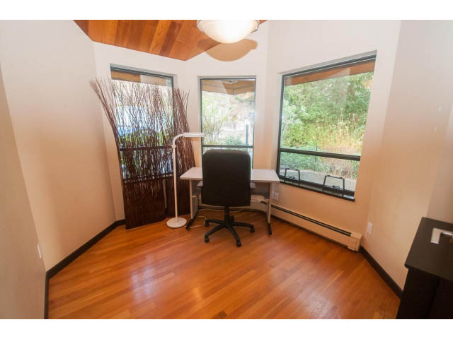 Bright office with hardwood floors, large windows, and a desk setup. - 4251A Rockbank, West Vancouver