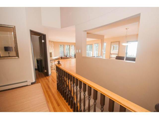 Staircase leading to upper level with wooden banister and hardwood floors. - 4251A Rockbank, West Vancouver