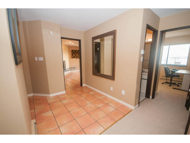 Bright living room with tiled floor, large window, and modern furniture. - 4251A Rockbank, West Vancouver