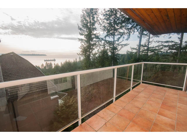 Furnished balcony with glass railings and view of the sea and forest. - 4251A Rockbank, West Vancouver