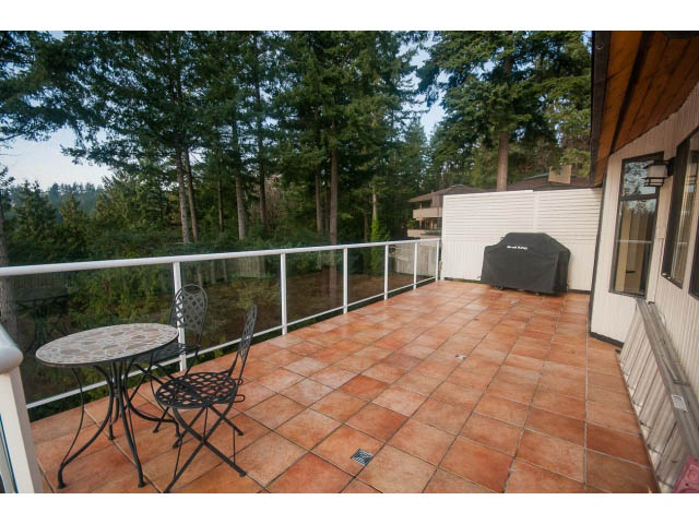 Furnished patio with tiled flooring, outdoor furniture, and forest view. - 4251A Rockbank, West Vancouver