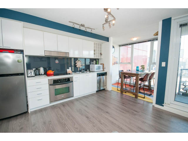 Bright kitchen with white cabinets, hardwood floors, and a city view. - 3105 - 602 Citadel Parade, Vancouver Downtown