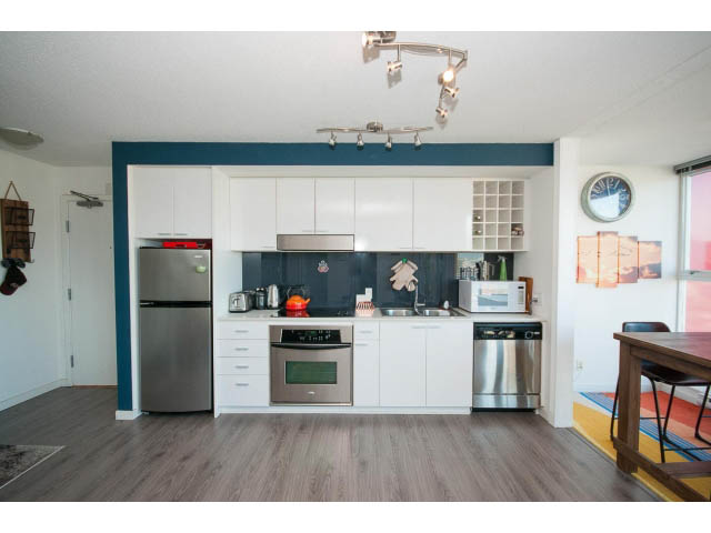 Bright kitchen with white cabinets, stainless steel appliances, and hardwood floors. - 3105 - 602 Citadel Parade, Vancouver Downtown