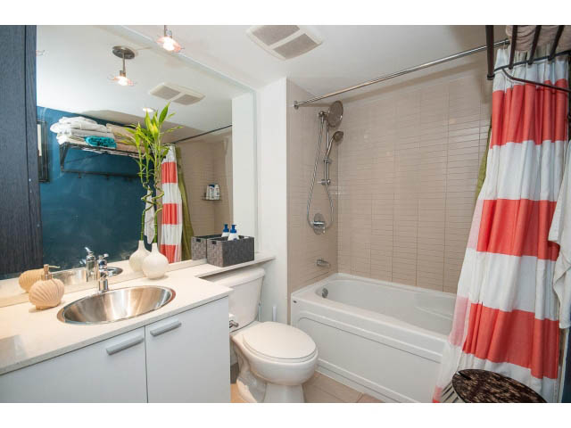 Furnished 1-bedroom bathroom with white countertops and red-and-white striped shower curtain. - 3105 - 602 Citadel Parade, Vancouver Downtown