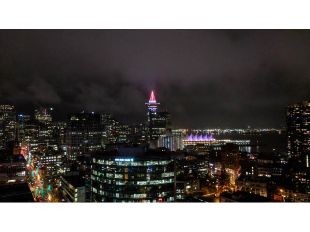 Bright 1-bedroom condo with stunning city view at night, featuring illuminated buildings and a vibrant downtown skyline.