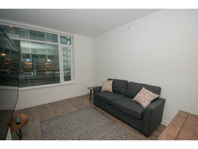 Furnished living room with hardwood floors, city view, and modern furniture. - 203 - 110 Switchmen St, Vancouver East Side