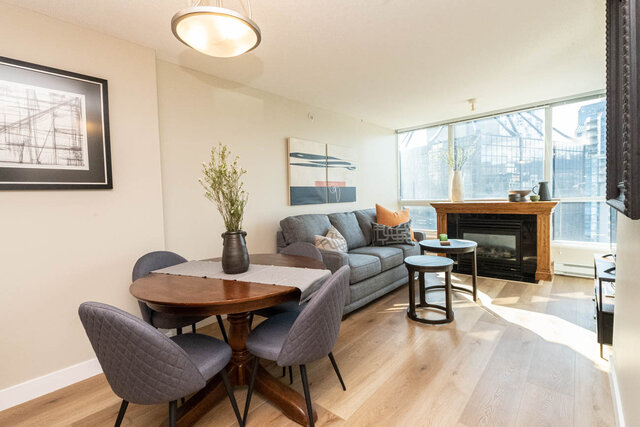 Spacious living room with hardwood floors, a cozy fireplace, and a city view. - 2303 - 1328 West Pender Street, Vancouver Downtown