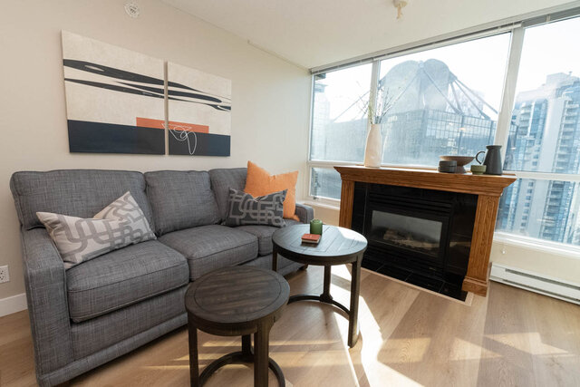 Cozy living room with hardwood floors, a city view, and a modern fireplace. - 2303 - 1328 West Pender Street, Vancouver Downtown