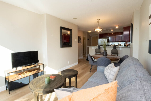 Spacious living room with hardwood floors, modern furniture, and a cozy corner setup. - 2303 - 1328 West Pender Street, Vancouver Downtown