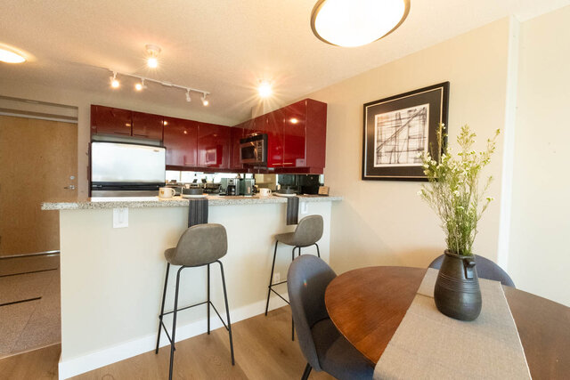 Bright kitchen with red cabinets, granite countertops, and modern bar stools. - 2303 - 1328 West Pender Street, Vancouver Downtown