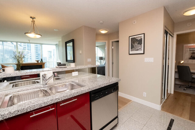 Bright kitchen with red cabinets, granite countertops, and a city view. - 2303 - 1328 West Pender Street, Vancouver Downtown