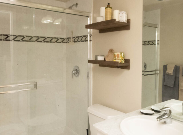 Spacious bathroom with floating shelves, marble countertop, and modern shower. - 2303 - 1328 West Pender Street, Vancouver Downtown