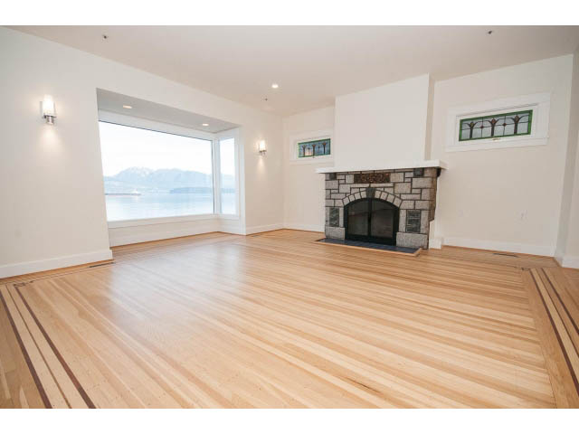 Bright living room with hardwood floors, fireplace, and city view. - 3655 Cameron Ave., Vancouver West Side