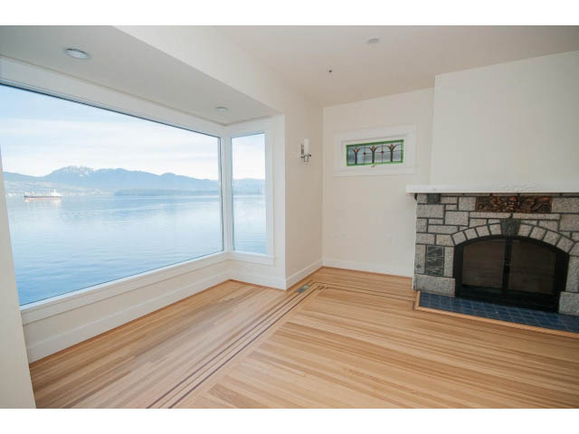 Bright living room with hardwood floors, fireplace, and stunning city view. - 3655 Cameron Ave., Vancouver West Side