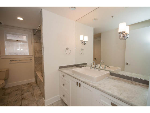 Bright bathroom with white cabinets, marble countertops, and a walk-in shower. - 3655 Cameron Ave., Vancouver West Side
