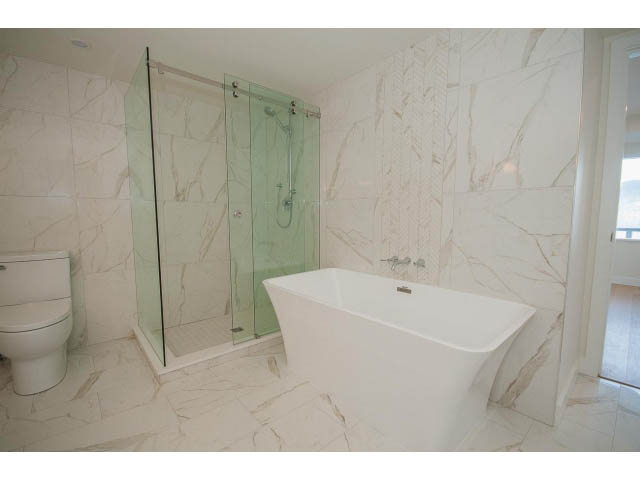 Modern bathroom with marble tiles and a glass shower enclosure. - 3655 Cameron Ave., Vancouver West Side