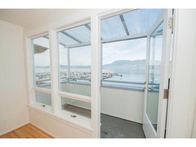 Bright living room with large windows offering a stunning city view, hardwood floors, and a cozy corner nook. - 3655 Cameron Ave., Vancouver West Side