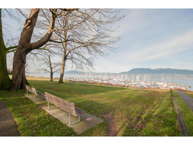 Bright outdoor space with a bench, grassy area, and a view of the marina and mountains. - 3655 Cameron Ave., Vancouver West Side