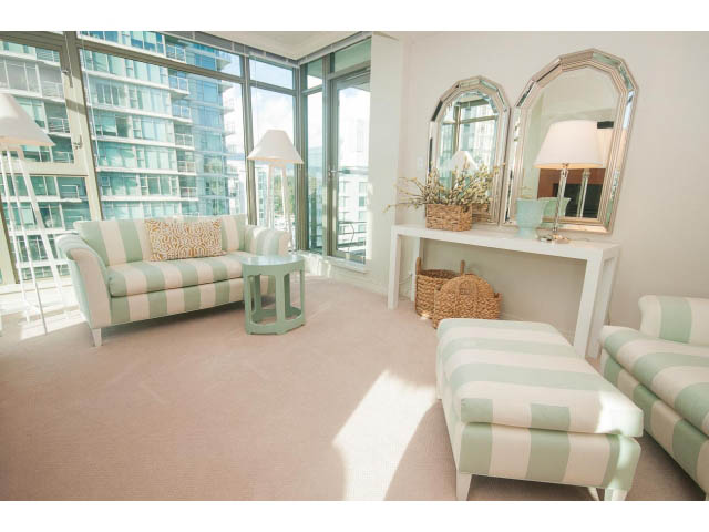 Bright living room with large windows, city view, and striped furniture. - 1402 - 1680 Bayshore Drive, Vancouver Downtown