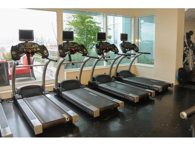 Bright and modern gym with large windows, city view, and Cybex treadmills. - 605 - 133 E Esplanade, North Vancouver