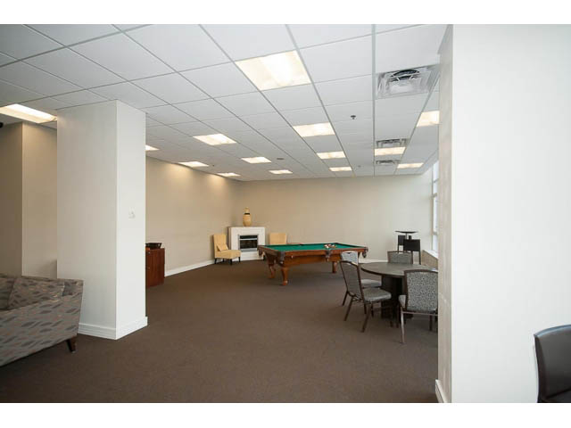 Furnished living room with pool table, couch, and fireplace. - 605 - 133 E Esplanade, North Vancouver