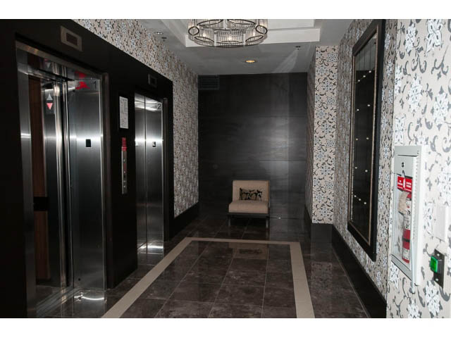 Elegant hallway with patterned wallpaper and modern elevator doors. - 605 - 133 E Esplanade, North Vancouver