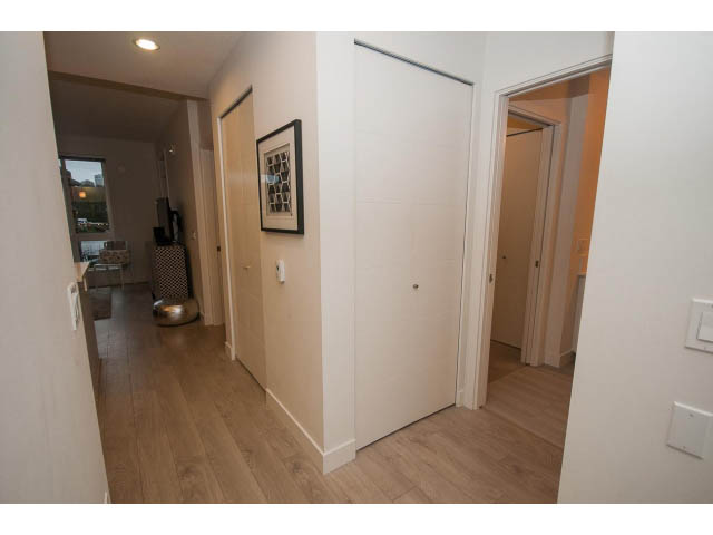 Bright hallway leading to a den with hardwood floors and a city view. - 416 - 733 West 3rd St, North Vancouver