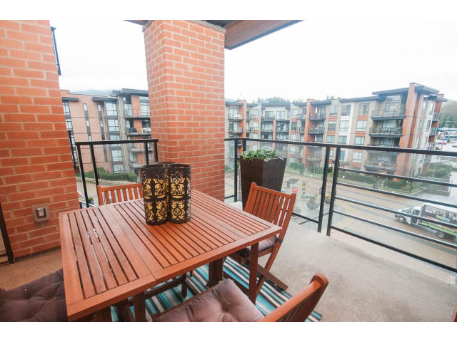 Furnished balcony with wooden furniture and city view. - 416 - 733 West 3rd St, North Vancouver