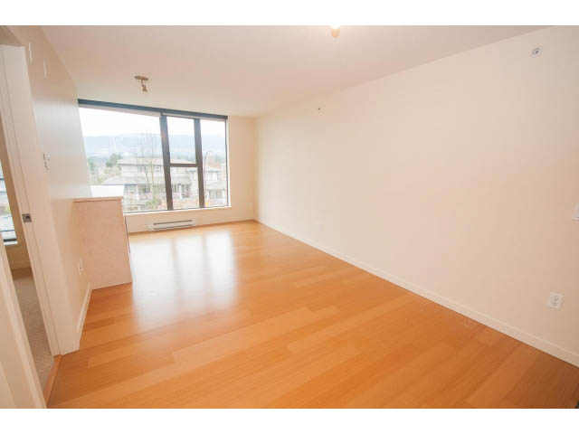 Bright living room with hardwood floors and a city view. - 407 - 683 Victoria Park West, North Vancouver